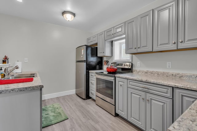 kitchen with light wood-type flooring, stainless steel appliances, gray cabinetry, and sink