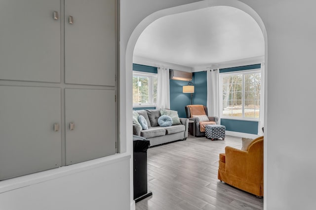 living room with light hardwood / wood-style floors, an AC wall unit, and plenty of natural light