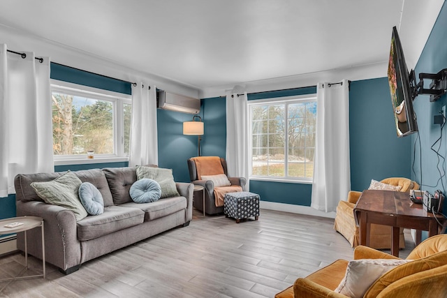 living room with an AC wall unit, a wealth of natural light, and light wood-type flooring