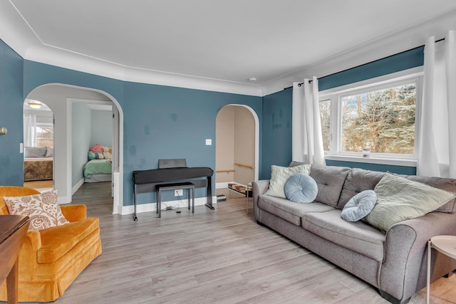 living room with light wood-type flooring and ornamental molding