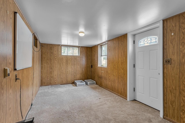 entryway featuring wooden walls and light carpet