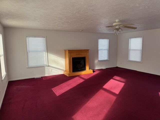 unfurnished living room with ceiling fan, carpet, and a textured ceiling