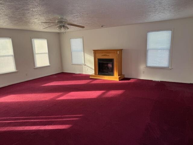 unfurnished living room featuring carpet, a textured ceiling, and ceiling fan