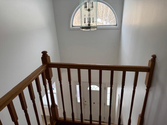 staircase with a notable chandelier