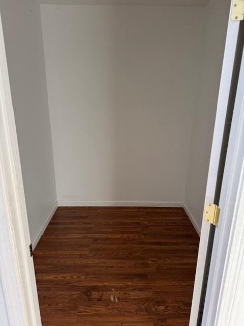 unfurnished room with dark hardwood / wood-style flooring