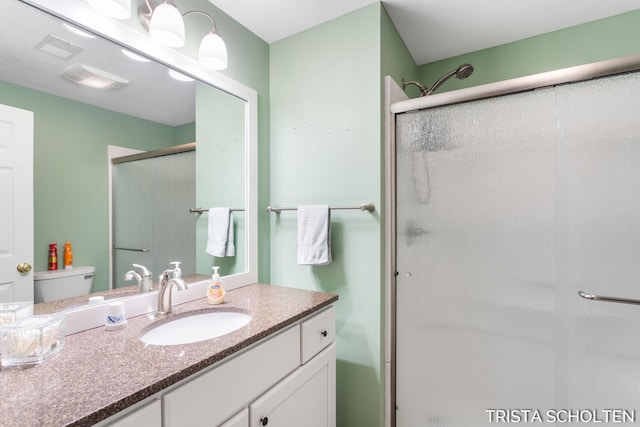 bathroom with vanity, toilet, and walk in shower