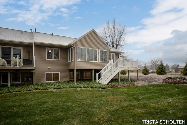 rear view of property with a wooden deck and a lawn