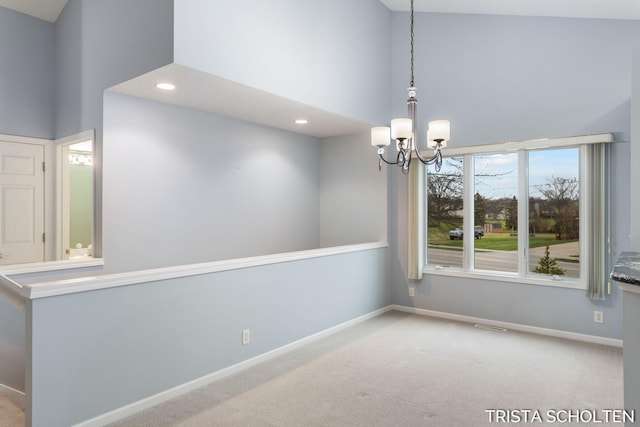 carpeted empty room with a chandelier and a high ceiling