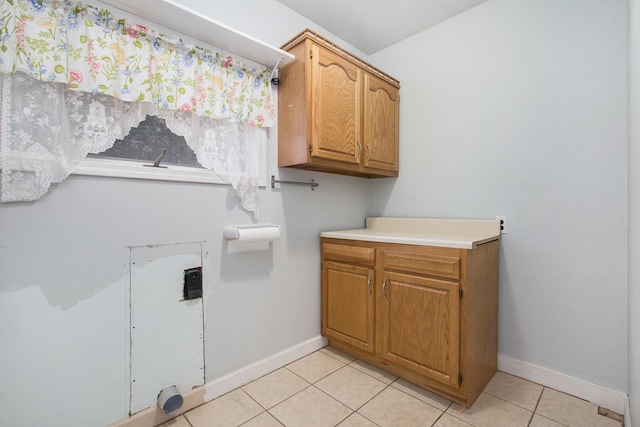 laundry room with light tile patterned floors and cabinets