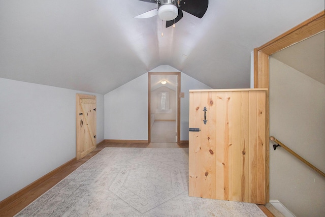 bonus room with light wood-type flooring, vaulted ceiling, and ceiling fan