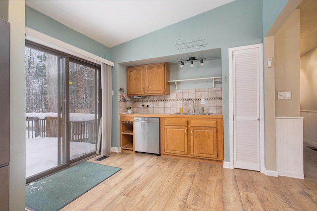 kitchen featuring dishwasher, light wood-type flooring, sink, and tasteful backsplash