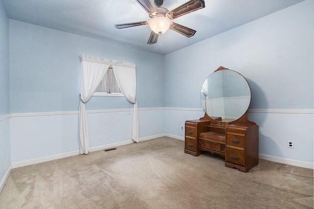 interior space with ceiling fan and light colored carpet