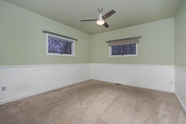 empty room featuring ceiling fan and light colored carpet