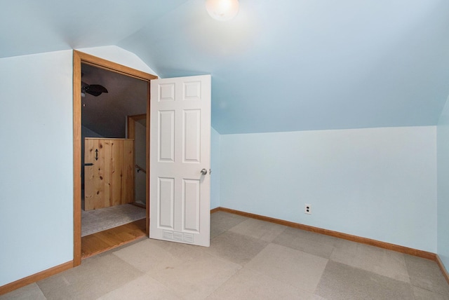 additional living space with hardwood / wood-style floors and vaulted ceiling