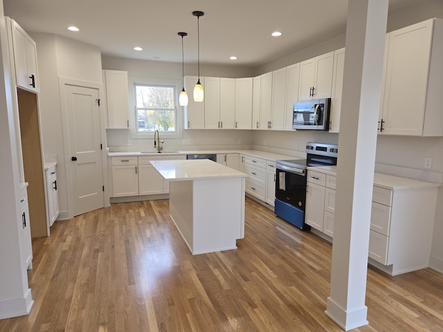 kitchen featuring a center island, white cabinetry, sink, and appliances with stainless steel finishes