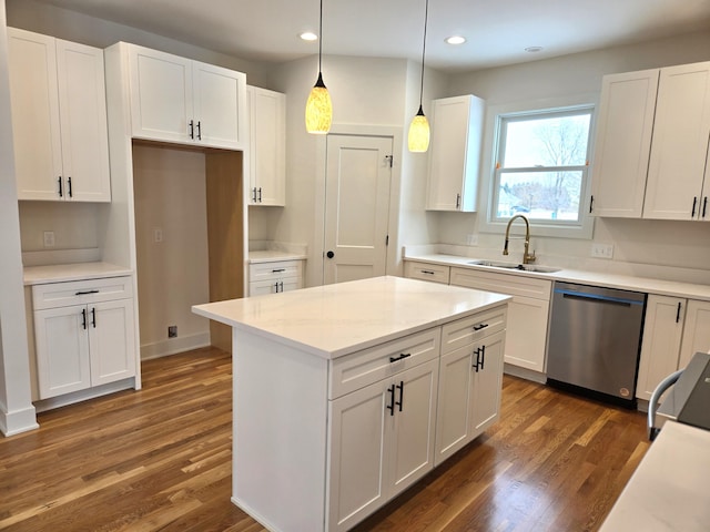 kitchen with dark hardwood / wood-style flooring, stainless steel dishwasher, sink, decorative light fixtures, and white cabinetry