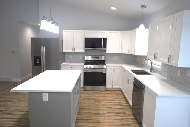 kitchen with a kitchen island, white cabinets, and appliances with stainless steel finishes