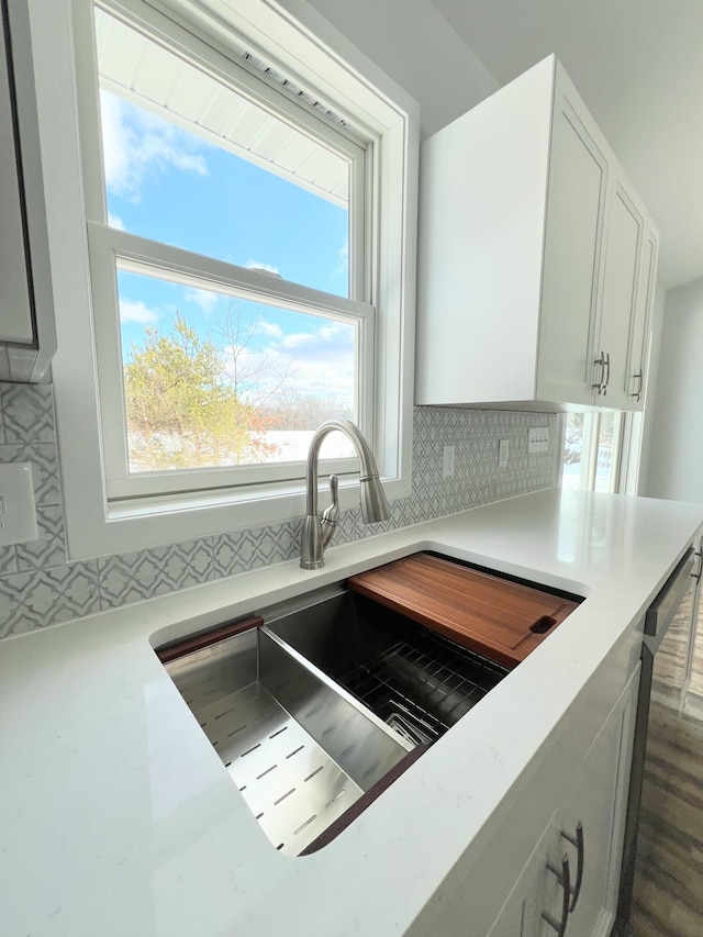 kitchen with sink, white cabinetry, dishwasher, and decorative backsplash