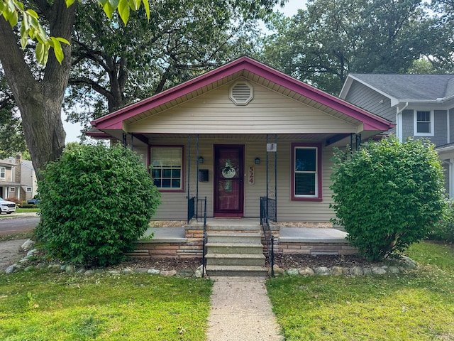 bungalow-style house with covered porch and a front lawn