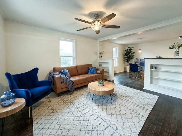 living room with hardwood / wood-style flooring, ceiling fan, a fireplace, and crown molding