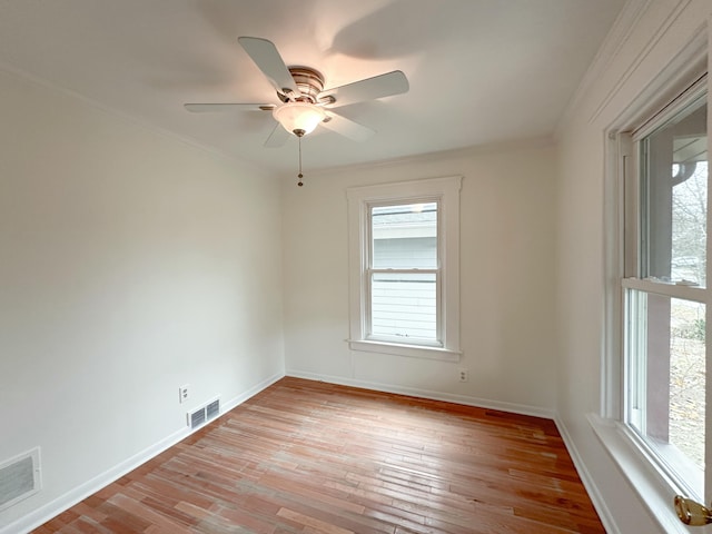 empty room with light hardwood / wood-style flooring, a wealth of natural light, and ceiling fan