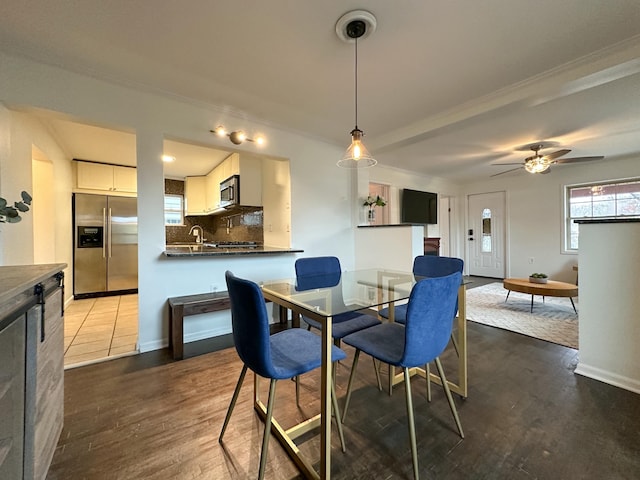 dining room with ceiling fan, sink, crown molding, and hardwood / wood-style flooring