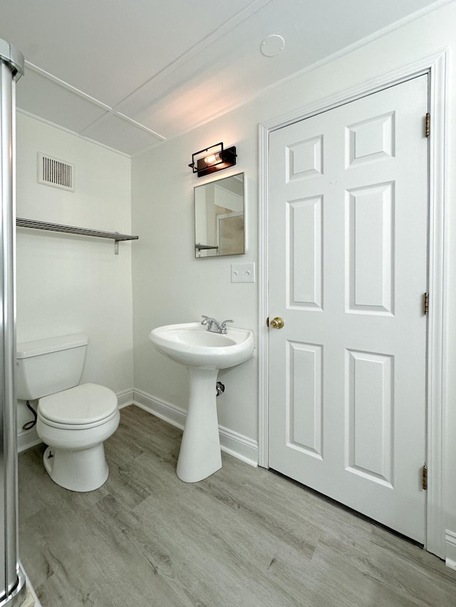 bathroom with hardwood / wood-style flooring and toilet