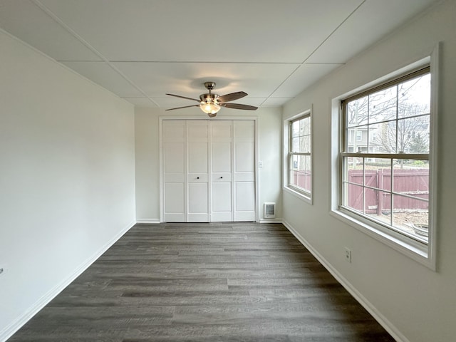 unfurnished bedroom featuring ceiling fan, dark hardwood / wood-style floors, and a closet