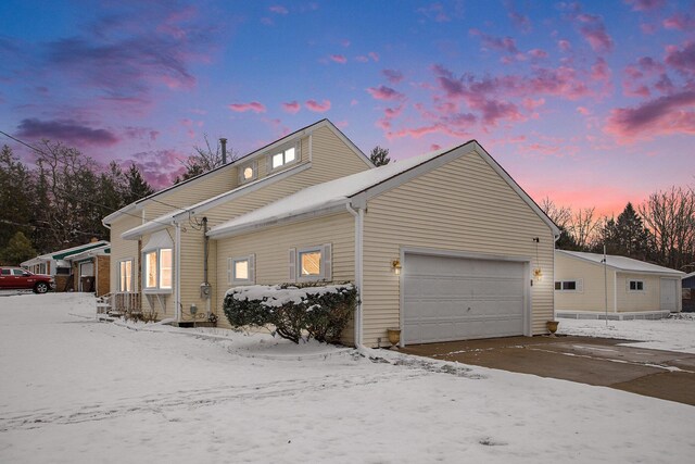 snow covered property with a garage