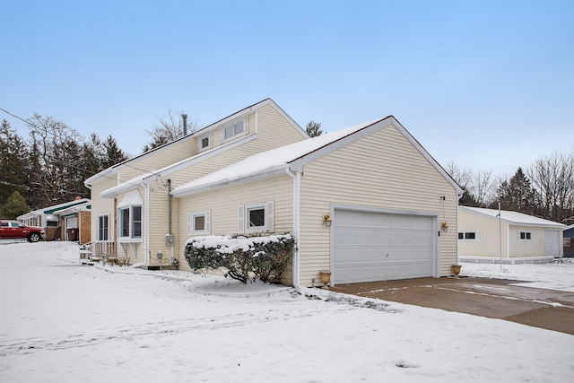 view of snowy exterior featuring a garage