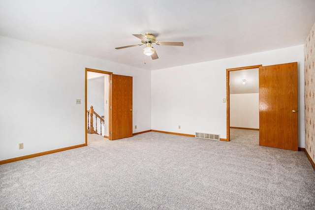 carpeted empty room featuring ceiling fan