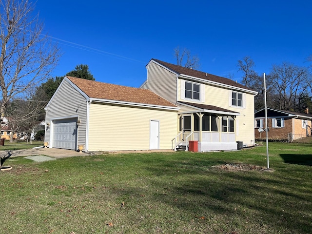 rear view of house featuring a lawn, a garage, and covered porch