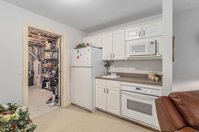 kitchen featuring white cabinets, light carpet, white appliances, and sink