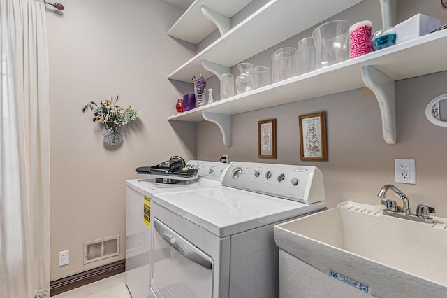 clothes washing area with washer and clothes dryer and sink