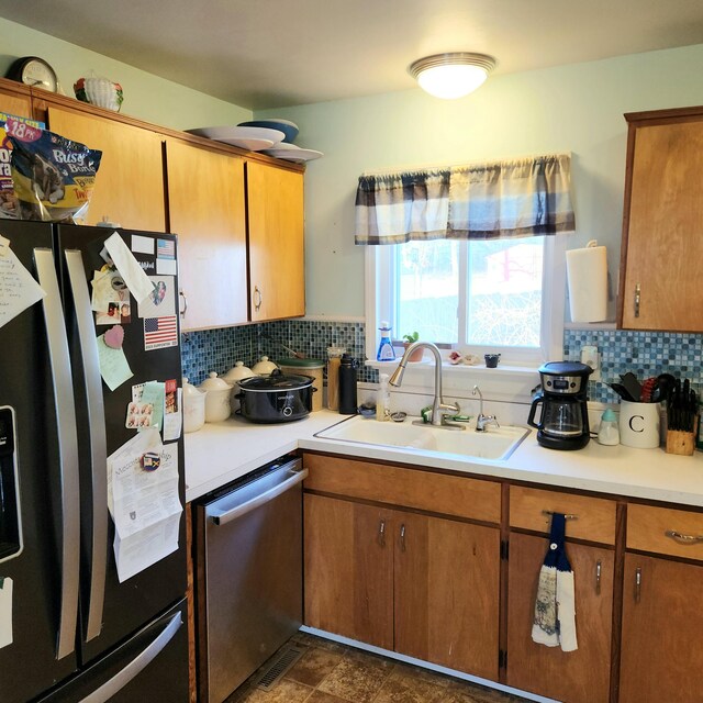 kitchen with sink, appliances with stainless steel finishes, and tasteful backsplash