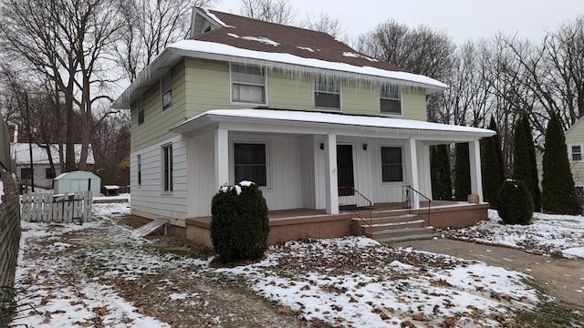 view of property with a storage unit and a porch