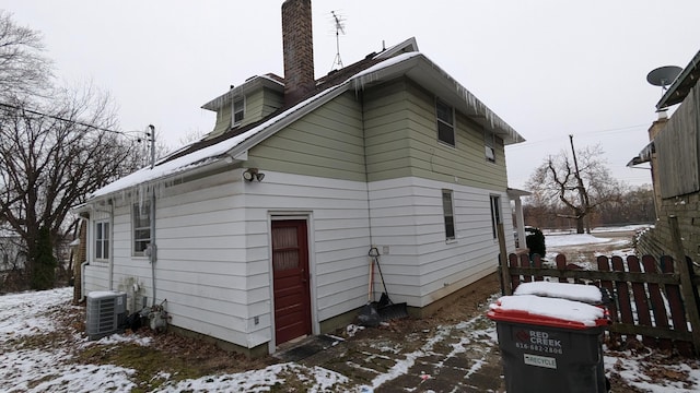 snow covered property with central AC unit