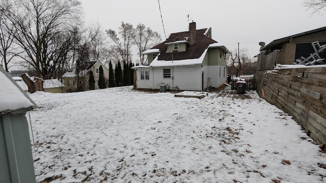 snow covered property with central AC