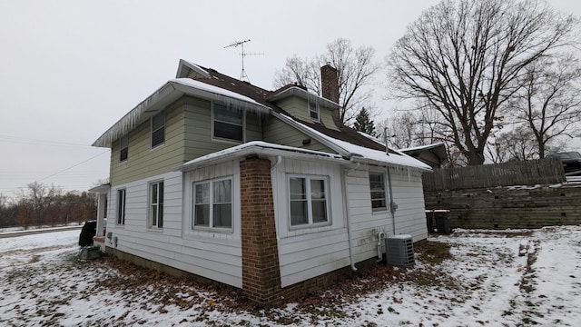 snow covered property with central air condition unit