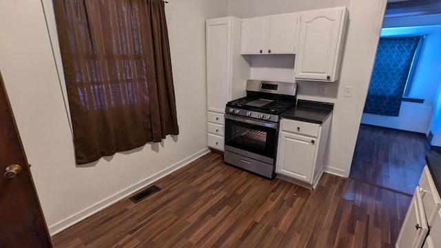 kitchen featuring stainless steel gas range oven, white cabinets, and dark hardwood / wood-style floors