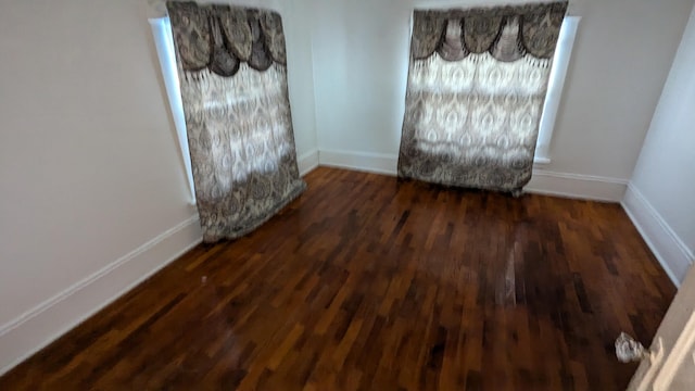 unfurnished room featuring dark wood-type flooring