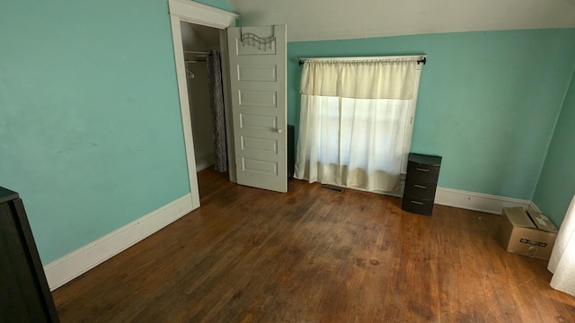 unfurnished bedroom featuring dark hardwood / wood-style flooring and a closet