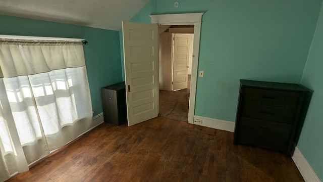 bedroom featuring lofted ceiling and dark wood-type flooring