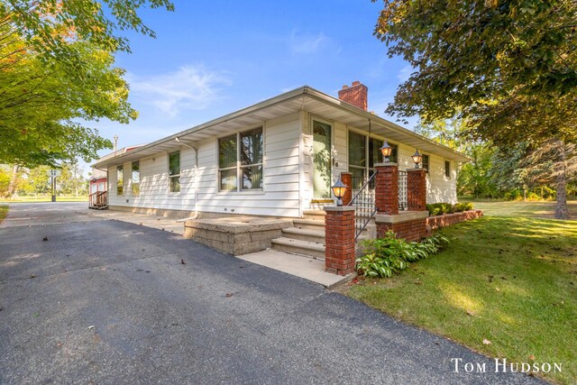 ranch-style house featuring a porch and a front yard