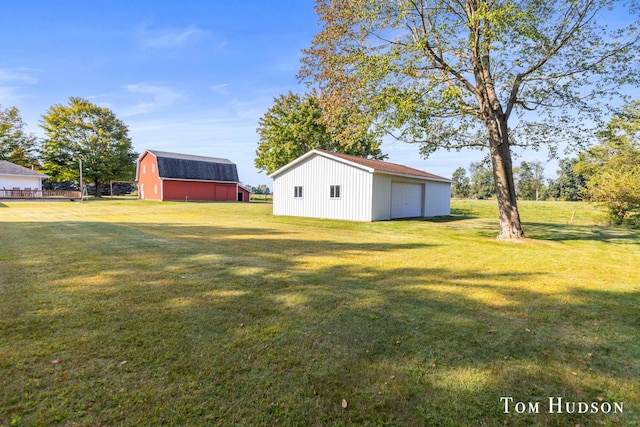 view of yard with a garage and an outbuilding