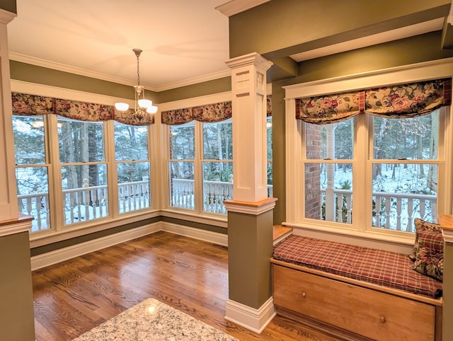 dining space with decorative columns, a wealth of natural light, and dark hardwood / wood-style flooring