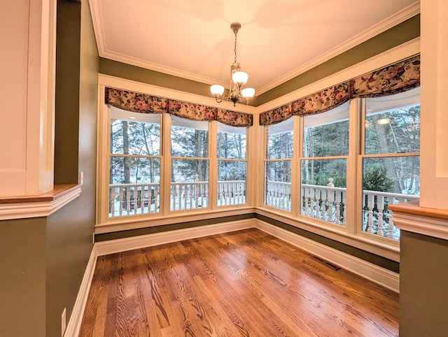 unfurnished dining area featuring hardwood / wood-style floors, ornamental molding, and a wealth of natural light