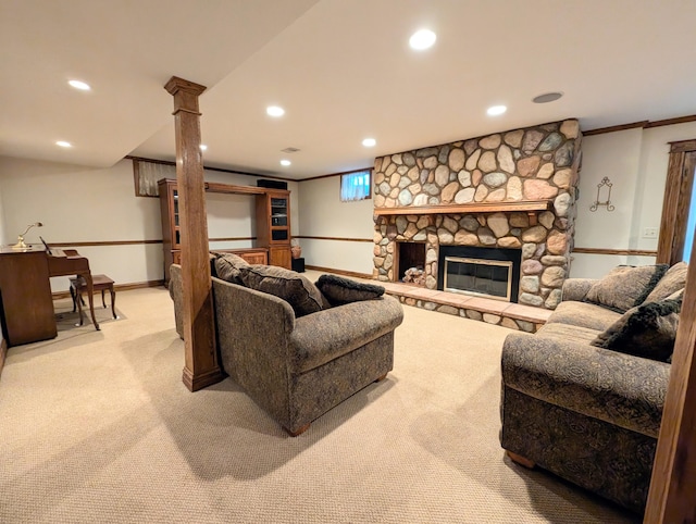 carpeted living room with a stone fireplace and ornamental molding