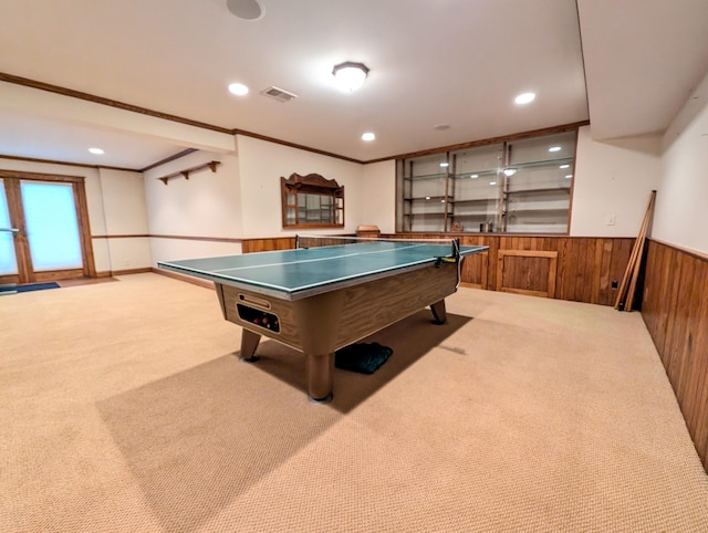 rec room featuring light carpet, wooden walls, and crown molding