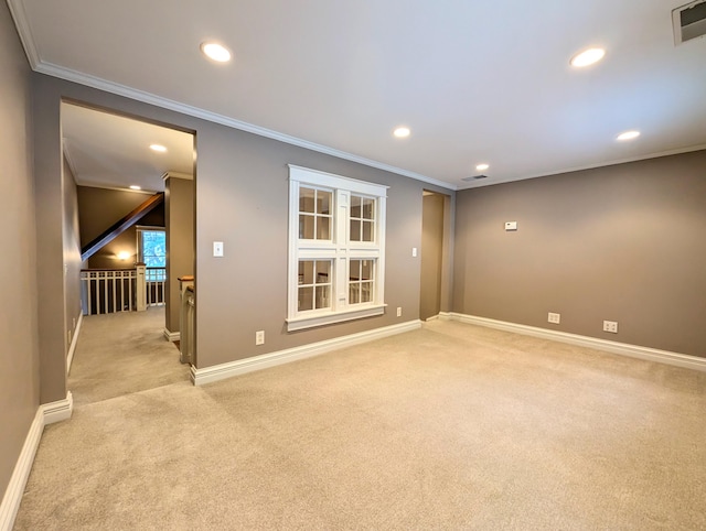 empty room featuring light colored carpet and crown molding